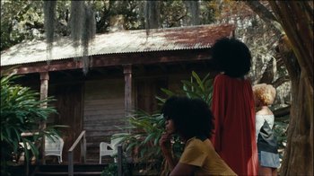 Movie still from “Lemonade” (2016), directed by Mark Romanek – Two women standing in front of a house; Extreme Wide shot, Over the shoulder angle