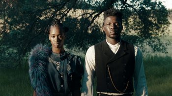 Movie still from “Lemonade” (2016), directed by Mark Romanek – A man and a woman standing next to each other in front of a tree; Medium shot, Low angle