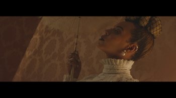Movie still from “Lemonade” (2016), directed by Mark Romanek – A woman holding an open umbrella in a room; Close Up shot, Low angle