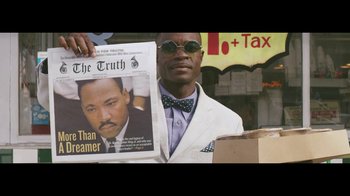 Movie still from “Lemonade” (2016), directed by Mark Romanek – A man in a white suit holding up a newspaper; Close Up shot, Low angle