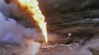 Movie still from “Lessons of Darkness” (1992), directed by Werner Herzog – An aerial view of an explosion in a field; Extreme Wide shot, High angle