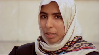 Movie still from “Lessons of Darkness” (1992), directed by Werner Herzog – A person wearing a head scarf; Close Up shot, Low angle