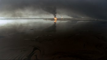 Movie still from “Lessons of Darkness” (1992), directed by Werner Herzog – An oil rig on fire in the middle of the night; Extreme Wide shot, High angle