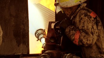 Movie still from “Lessons of Darkness” (1992), directed by Werner Herzog – A person with a helmet on a fire hydrant; Close Up shot, Low angle
