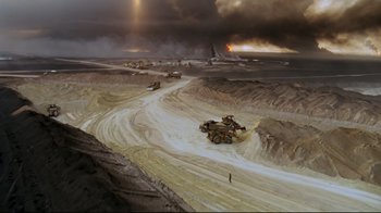 Movie still from “Lessons of Darkness” (1992), directed by Werner Herzog – An aerial view of an open pit with a lot of smoke coming out of it; Extreme Wide shot, High angle
