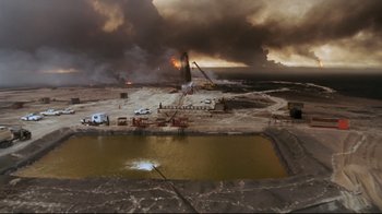 Movie still from “Lessons of Darkness” (1992), directed by Werner Herzog – An oil field is burning in the middle of the night; Extreme Wide shot, High angle