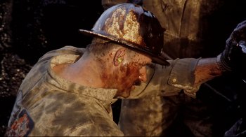 Movie still from “Lessons of Darkness” (1992), directed by Werner Herzog – A person with a helmet on; Close Up shot, High angle