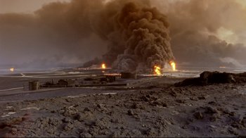 Movie still from “Lessons of Darkness” (1992), directed by Werner Herzog – An oil fire is burning in the middle of the desert; Extreme Wide shot, High angle