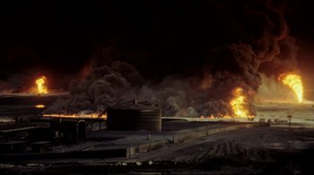 Movie still from “Lessons of Darkness” (1992), directed by Werner Herzog – An oil field is on fire at night time; Extreme Wide shot, High angle