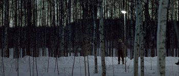 Movie still from “Let the Right One In” (2008), directed by Tomas Alfredson – A person standing in the snow next to trees; Extreme Wide shot, Low angle