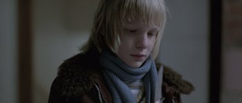Movie still from “Let the Right One In” (2008), directed by Tomas Alfredson – A young boy wearing a blue scarf and a brown jacket; Close Up shot, Low angle