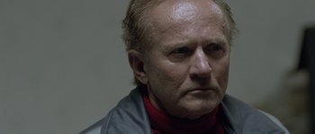 Movie still from “Let the Right One In” (2008), directed by Tomas Alfredson – An older man wearing a jacket and a red sweater; Close Up shot, Low angle