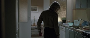 Movie still from “Let the Right One In” (2008), directed by Tomas Alfredson – A woman standing in a room wearing a sweater; Medium shot, Low angle