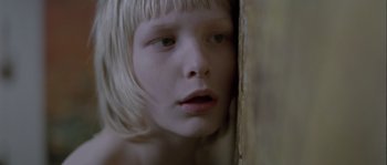 Movie still from “Let the Right One In” (2008), directed by Tomas Alfredson – A young girl with blonde hair looking into a mirror; Close Up shot, Overhead angle