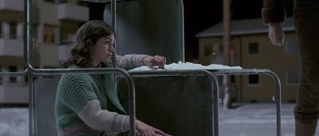 Movie still from “Let the Right One In” (2008), directed by Tomas Alfredson – A young girl sitting on top of a bench; Medium shot, Over the shoulder angle