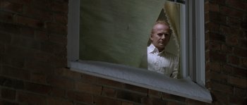 Movie still from “Let the Right One In” (2008), directed by Tomas Alfredson – A man standing in front of a window looking at himself in the mirror; Medium shot, Low angle