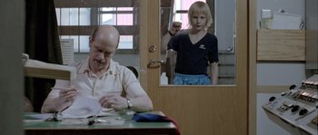 Movie still from “Let the Right One In” (2008), directed by Tomas Alfredson – A man sitting at a table in front of a woman; Medium shot, Over the shoulder angle