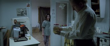 Movie still from “Let the Right One In” (2008), directed by Tomas Alfredson – A woman standing next to a man in a room; Medium shot, Over the shoulder angle