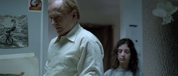 Movie still from “Let the Right One In” (2008), directed by Tomas Alfredson – An old man and a young girl standing next to each other; Medium shot, Over the shoulder angle
