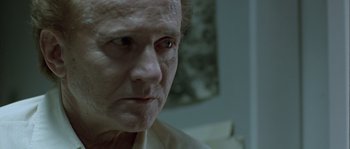 Movie still from “Let the Right One In” (2008), directed by Tomas Alfredson – An old man with a white shirt and a white beard looking at the camera; Close Up shot, Low angle
