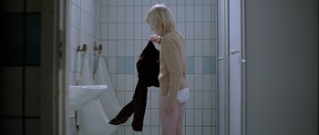 Movie still from “Let the Right One In” (2008), directed by Tomas Alfredson – A woman in a bathroom holding onto a shirt; Medium shot, Overhead angle