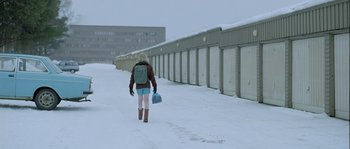 Movie still from “Let the Right One In” (2008), directed by Tomas Alfredson – A person walking in the snow with a backpack; Wide shot, Low angle
