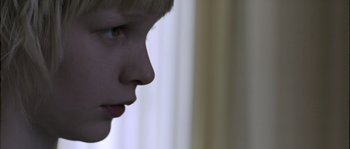 Movie still from “Let the Right One In” (2008), directed by Tomas Alfredson – A child's face with a curtain in the background; Close Up shot, Low angle