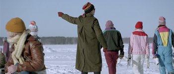 Movie still from “Let the Right One In” (2008), directed by Tomas Alfredson – Two people walking in the snow with a snowboard; Medium shot, Low angle