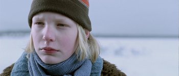 Movie still from “Let the Right One In” (2008), directed by Tomas Alfredson – A person wearing a hat and a scarf; Close Up shot, Over the shoulder angle