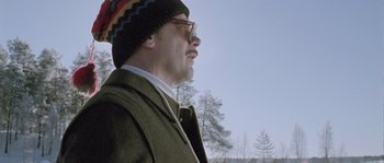 Movie still from “Let the Right One In” (2008), directed by Tomas Alfredson – A man wearing a green coat and a colorful hat; Close Up shot, Low angle