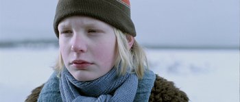 Movie still from “Let the Right One In” (2008), directed by Tomas Alfredson – A young woman wearing a hat and a scarf; Close Up shot, Over the shoulder angle