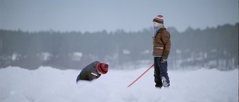 Movie still from “Let the Right One In” (2008), directed by Tomas Alfredson – Two people standing in the middle of a snowy field; Wide shot, Over the shoulder angle
