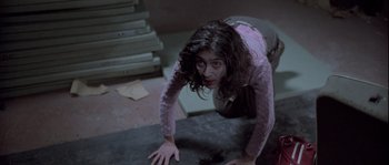 Movie still from “Let the Right One In” (2008), directed by Tomas Alfredson – A woman in a purple shirt is on the ground; Medium shot, High angle