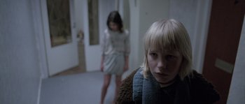 Movie still from “Let the Right One In” (2008), directed by Tomas Alfredson – Two young girls are standing in a hallway; Close Up shot, Over the shoulder angle