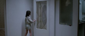 Movie still from “Let the Right One In” (2008), directed by Tomas Alfredson – A woman is standing in front of a door; Wide shot, Over the shoulder angle