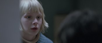 Movie still from “Let the Right One In” (2008), directed by Tomas Alfredson – A young girl with blonde hair is looking at the camera; Close Up shot, Over the shoulder angle