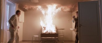 Movie still from “Let the Right One In” (2008), directed by Tomas Alfredson – A fire is burning in the middle of a room; Wide shot, High angle