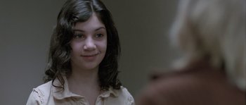 Movie still from “Let the Right One In” (2008), directed by Tomas Alfredson – A young woman smiles at the camera in front of a mirror; Close Up shot, Over the shoulder angle