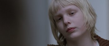 Movie still from “Let the Right One In” (2008), directed by Tomas Alfredson – A person with long blonde hair; Close Up shot, Low angle