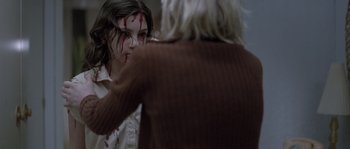 Movie still from “Let the Right One In” (2008), directed by Tomas Alfredson – A person with blood on their face and a person with a hand on a woman's shoulder; Close Up shot, Over the shoulder angle