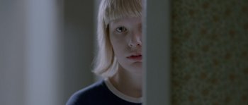 Movie still from “Let the Right One In” (2008), directed by Tomas Alfredson – A young girl with blonde hair looking into a mirror; Close Up shot, Over the shoulder angle