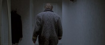 Movie still from “Let the Right One In” (2008), directed by Tomas Alfredson – A man walking down the hall way of a house; Medium shot, Low angle