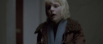 Movie still from “Let the Right One In” (2008), directed by Tomas Alfredson – A woman with blonde hair wearing a brown jacket; Close Up shot, Over the shoulder angle
