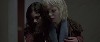 Movie still from “Let the Right One In” (2008), directed by Tomas Alfredson – Two women are holding their heads together in a dark room; Close Up shot, Over the shoulder angle