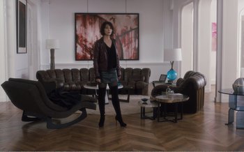 Movie still from “Let the Sunshine In” (2017), directed by Claire Denis – A woman standing in front of a painting in a living room; Wide shot, Over the shoulder angle