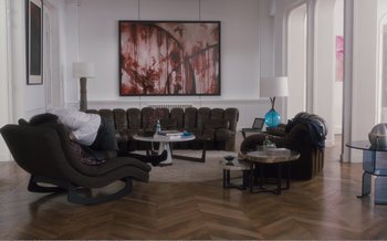 Movie still from “Let the Sunshine In” (2017), directed by Claire Denis – A living room filled with lots of furniture and a painting on the wall; Wide shot, High angle