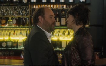 Movie still from “Let the Sunshine In” (2017), directed by Claire Denis – A man and a woman kissing in front of a bar; Medium shot, Over the shoulder angle