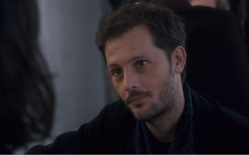 Movie still from “Let the Sunshine In” (2017), directed by Claire Denis – A person sitting in front of a camera; Close Up shot, Over the shoulder angle