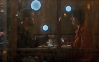 Movie still from “Let the Sunshine In” (2017), directed by Claire Denis – A man and a woman sitting at a dinner table; Medium shot, Over the shoulder angle