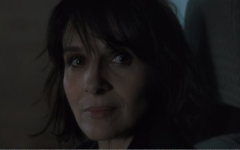 Movie still from “Let the Sunshine In” (2017), directed by Claire Denis – A woman's face in a dark room; Close Up shot, Over the shoulder angle